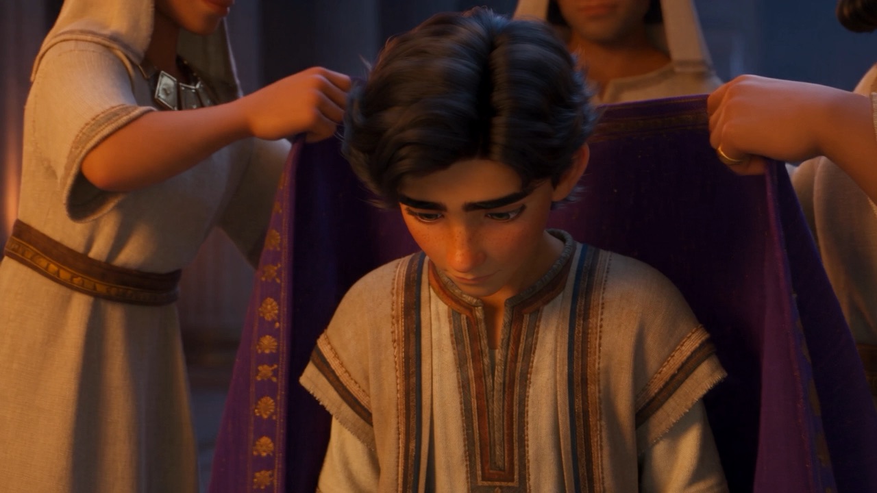 Attendants dress the bowed young man in purple