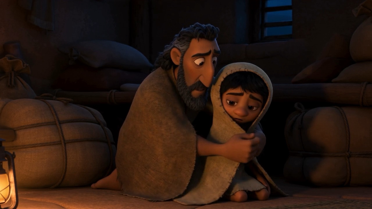 A father packing beside a child who will not let go