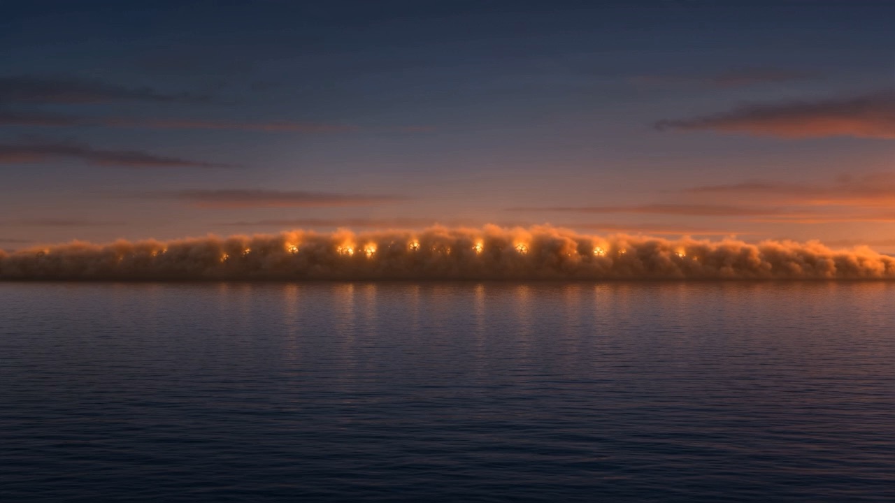 From across the water, a long line of torches at dusk