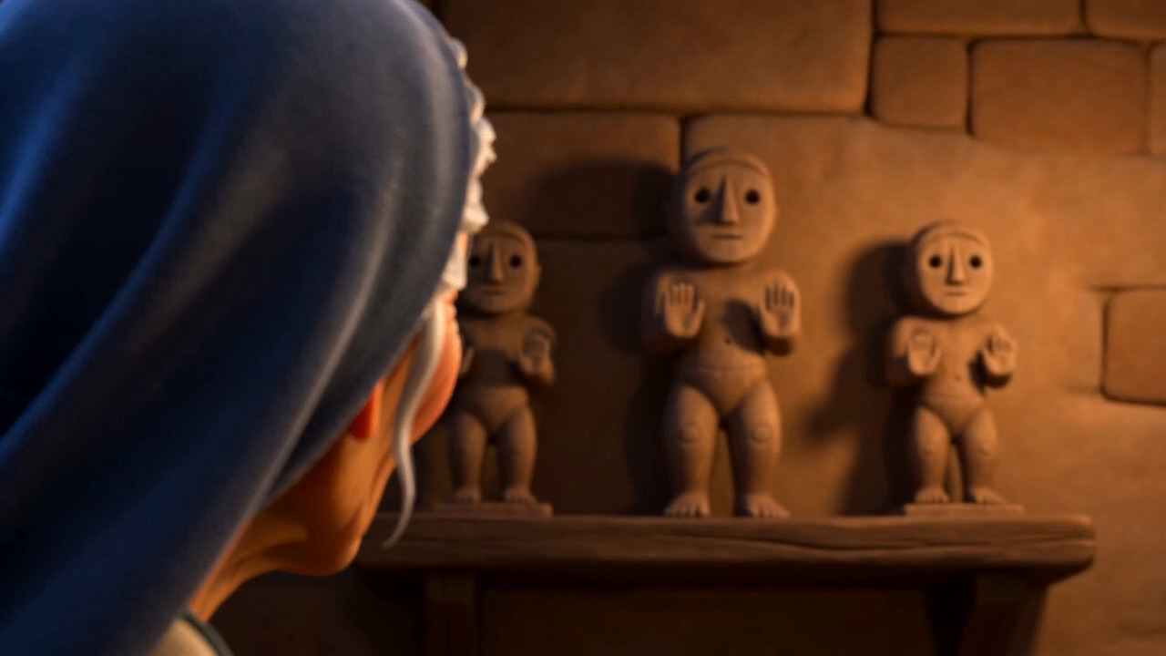 Three small carved figures on a shelf on the wall