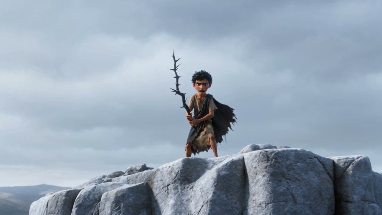 A boy standing on a white rock, holding something up