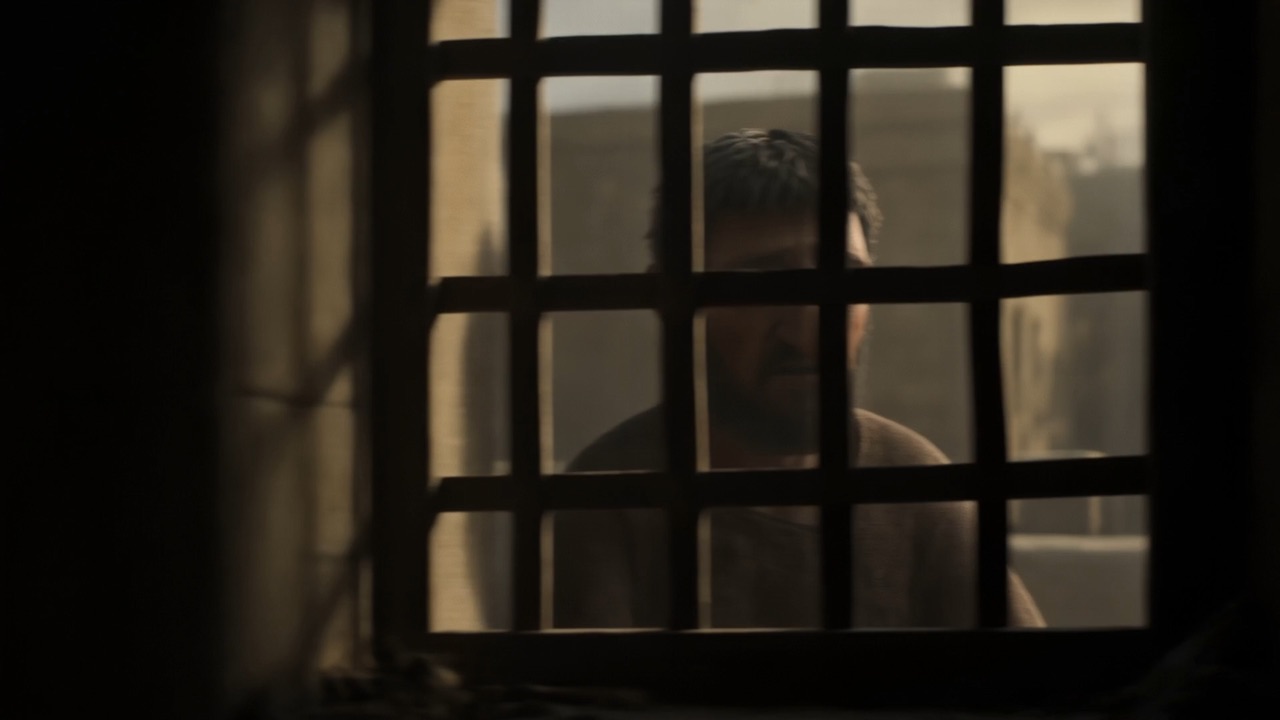 A face behind the bars, watching nothing happen